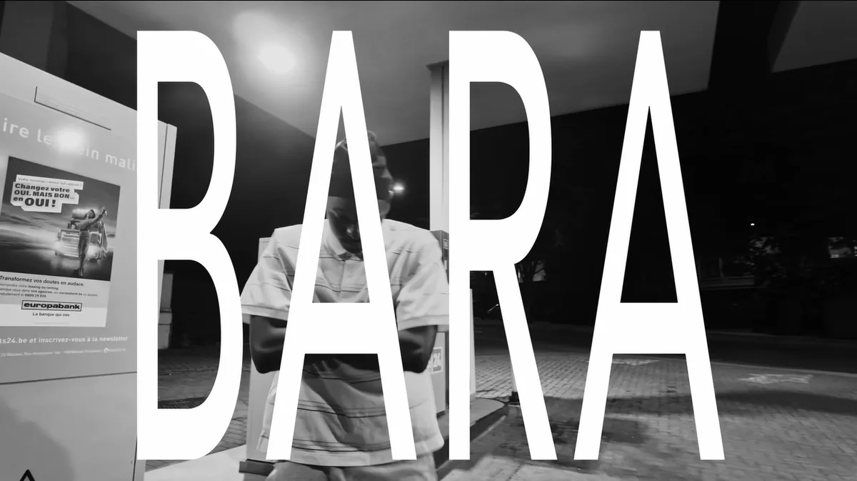 Image en noir et blanc de jackbozo dans une station-service la nuit, le mot « BARA » en grandes lettres blanches par-dessus